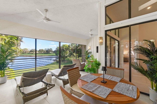 sunroom with a water view and ceiling fan