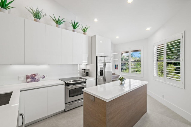 kitchen with light tile patterned flooring, a kitchen island, white cabinets, backsplash, and stainless steel appliances