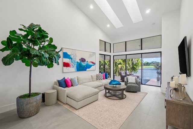 living room with a skylight, high vaulted ceiling, and light tile patterned flooring