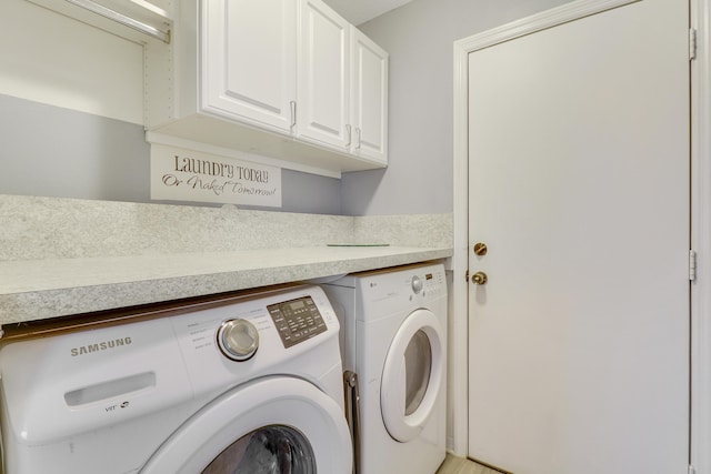 laundry room featuring cabinets and washer and dryer