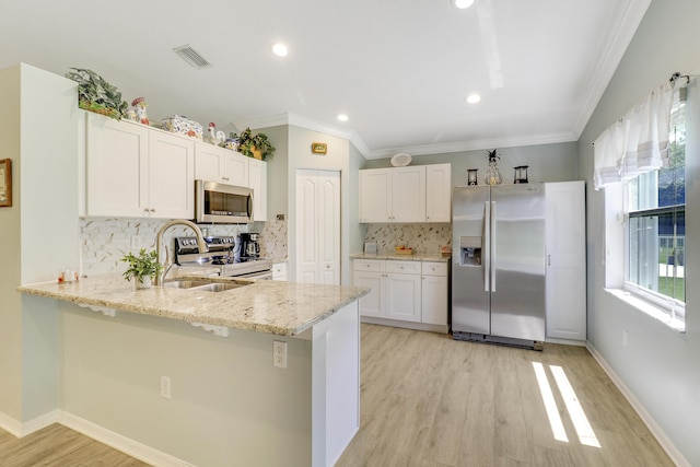 kitchen featuring stainless steel appliances, sink, white cabinets, and kitchen peninsula