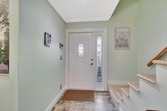 foyer with baseboards and stairway