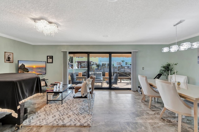 living room featuring ornamental molding, a textured ceiling, and a notable chandelier