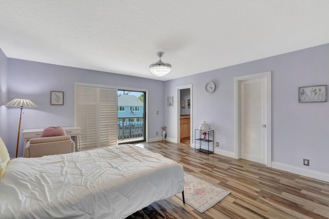 bedroom with light wood-style floors, baseboards, and access to exterior
