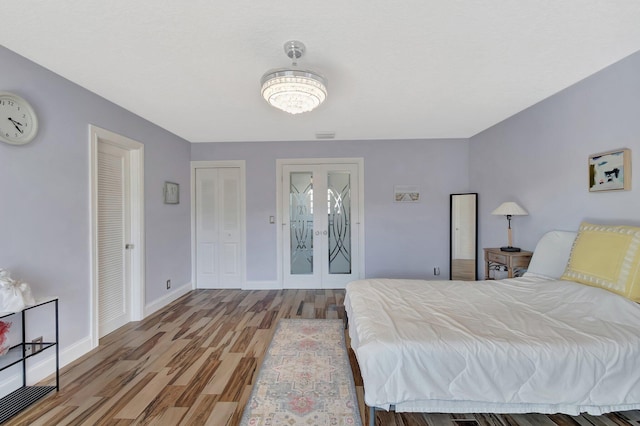 bedroom with baseboards, french doors, and light wood-style floors