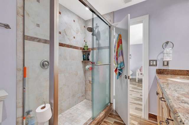 bathroom featuring vanity, an enclosed shower, and hardwood / wood-style floors