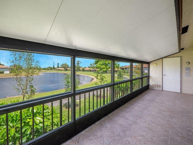 unfurnished sunroom featuring a water view and vaulted ceiling