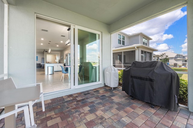 view of patio featuring a grill and a sunroom