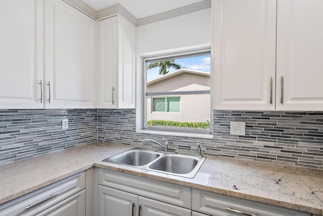 kitchen with white cabinets, a sink, and backsplash