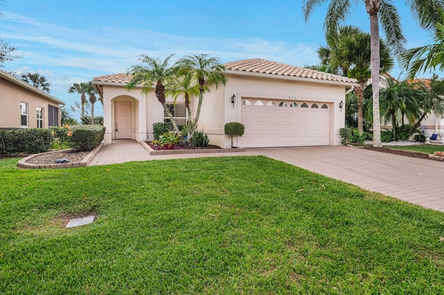 mediterranean / spanish-style home with a garage and a front lawn