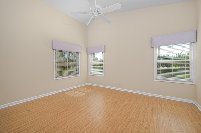 spare room featuring ceiling fan, vaulted ceiling, and light wood-type flooring