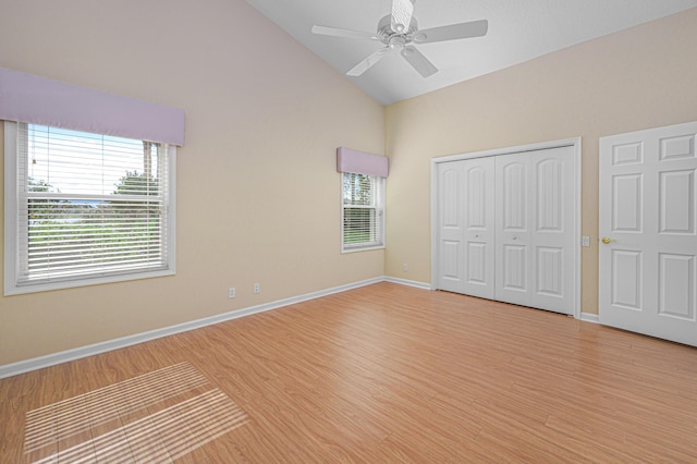 unfurnished bedroom with a closet, high vaulted ceiling, ceiling fan, and light hardwood / wood-style flooring