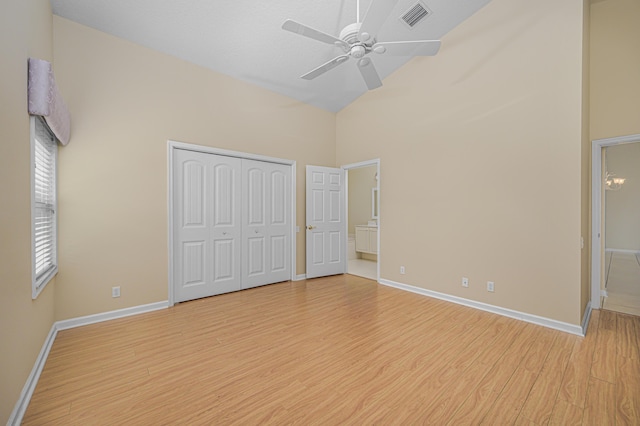 unfurnished bedroom featuring high vaulted ceiling, ceiling fan, and light wood-type flooring