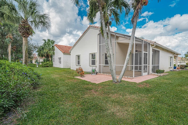 back of property with a patio area, ceiling fan, and a lawn