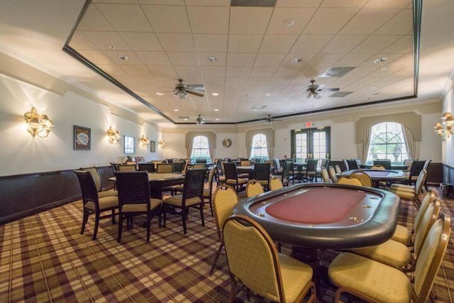 rec room featuring a tray ceiling, ornamental molding, ceiling fan, and carpet flooring