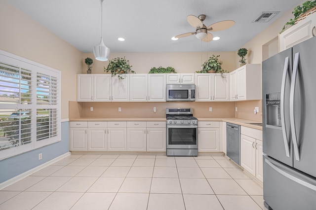 kitchen with stainless steel appliances, white cabinetry, and decorative light fixtures