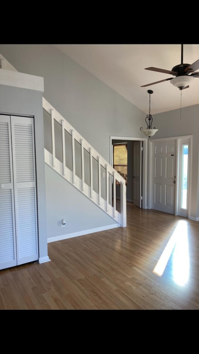 foyer entrance with vaulted ceiling, dark hardwood / wood-style floors, and ceiling fan