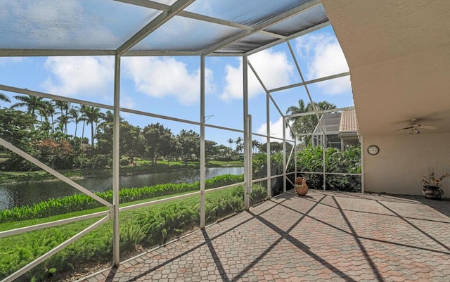 unfurnished sunroom featuring a water view and ceiling fan