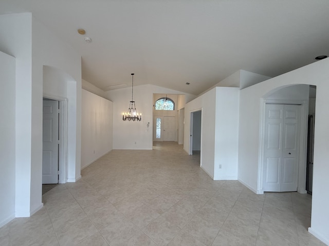 spare room featuring an inviting chandelier and vaulted ceiling