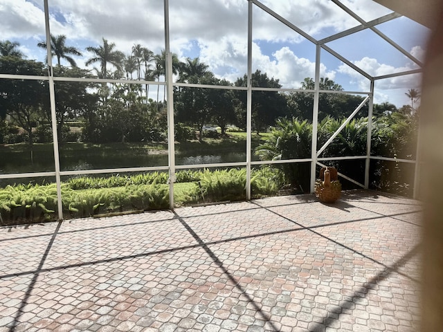 unfurnished sunroom featuring a water view