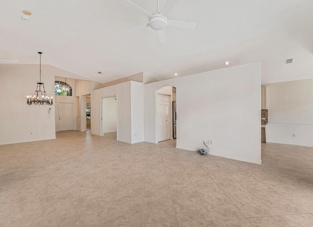 empty room featuring arched walkways, ceiling fan with notable chandelier, visible vents, baseboards, and vaulted ceiling