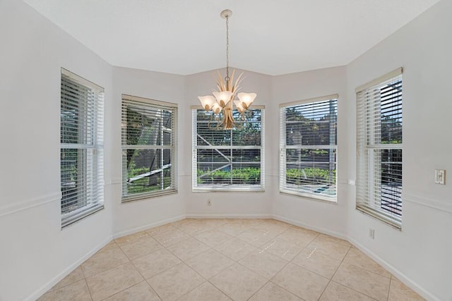 unfurnished dining area featuring light tile patterned floors, baseboards, and an inviting chandelier