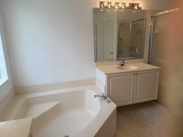 bathroom featuring vanity, tile patterned floors, and a tub to relax in