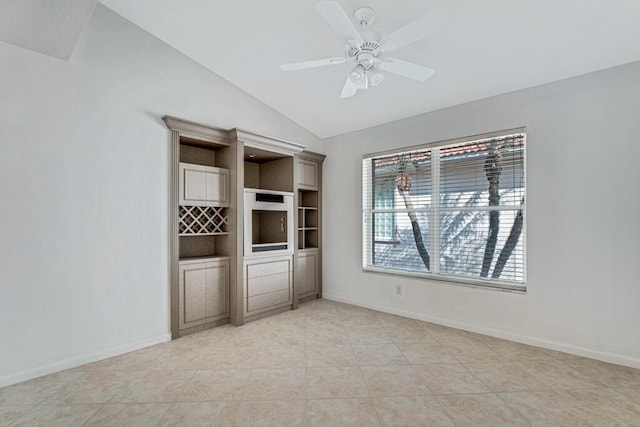 unfurnished bedroom with vaulted ceiling, a ceiling fan, and baseboards