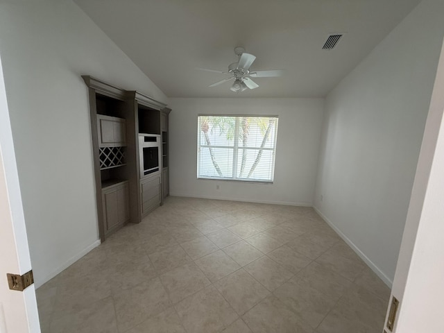 tiled empty room with lofted ceiling and ceiling fan