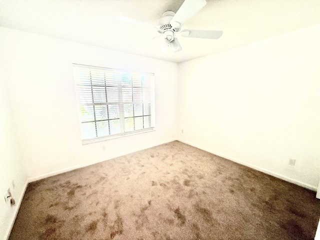 carpeted empty room featuring ceiling fan