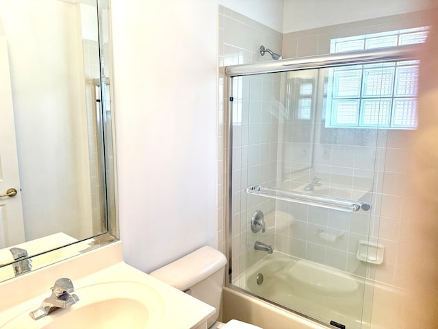 full bathroom featuring vanity, shower / bath combination with glass door, and toilet