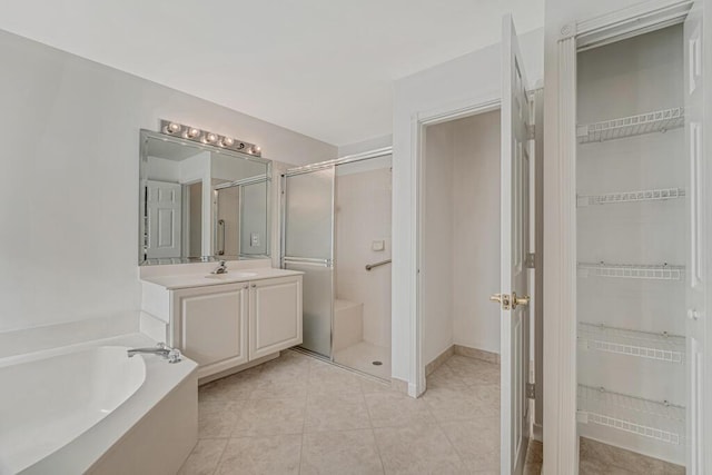 full bathroom with a garden tub, tile patterned flooring, vanity, a spacious closet, and a shower stall