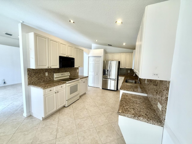 kitchen featuring lofted ceiling, sink, stainless steel fridge, electric stove, and white cabinets