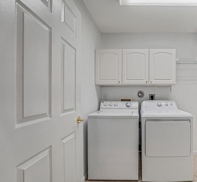 washroom featuring cabinet space and washer and clothes dryer