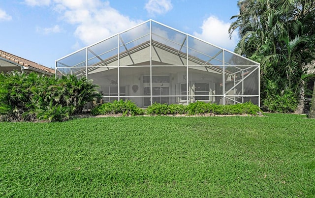 back of property featuring a lanai and a yard