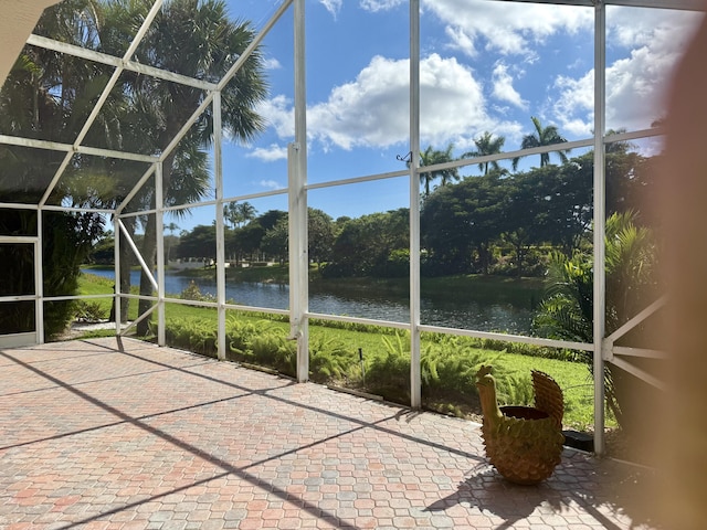 unfurnished sunroom featuring a water view