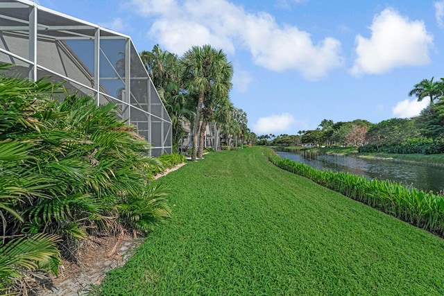 view of yard featuring glass enclosure and a water view