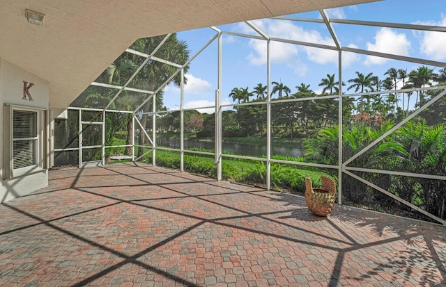 view of patio featuring a water view and glass enclosure