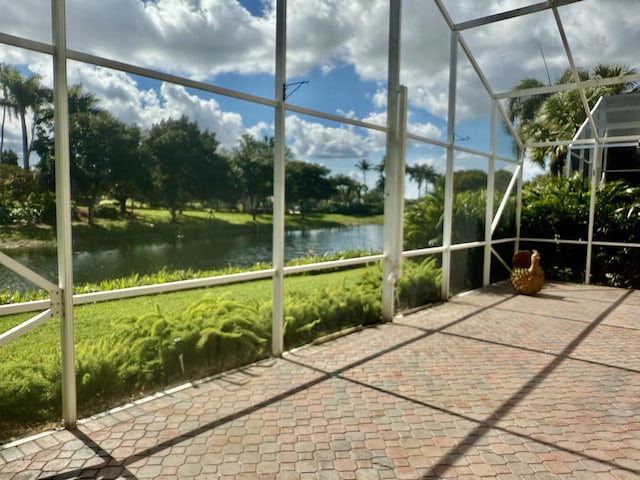 unfurnished sunroom featuring a water view