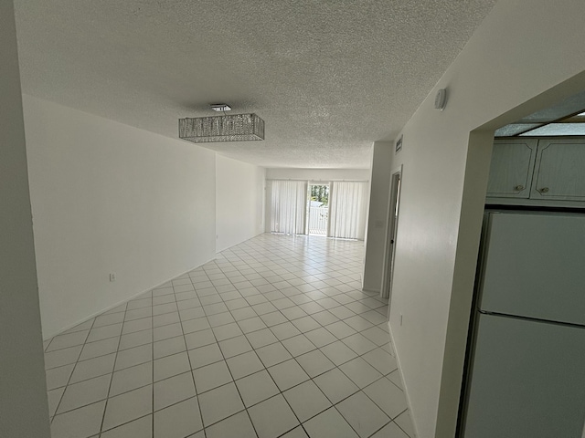 tiled empty room with a textured ceiling