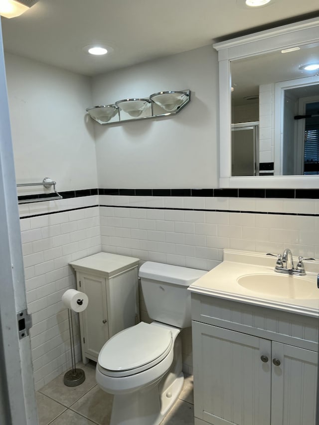 bathroom featuring tile walls, tile patterned flooring, vanity, an enclosed shower, and toilet