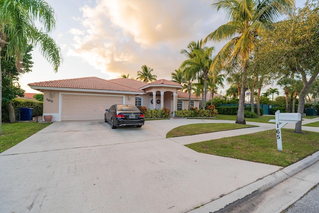 mediterranean / spanish-style home with a yard and a garage