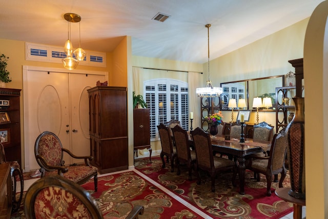 dining space with vaulted ceiling and an inviting chandelier