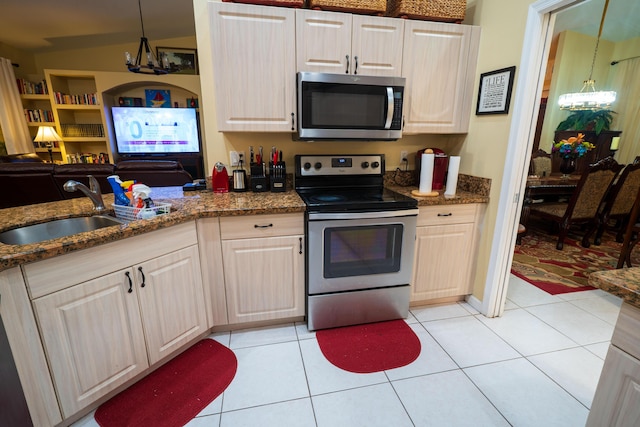 kitchen with appliances with stainless steel finishes, sink, pendant lighting, and light tile patterned floors