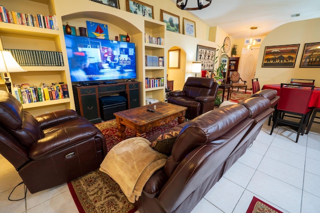 living room featuring vaulted ceiling, light tile patterned floors, and built in features