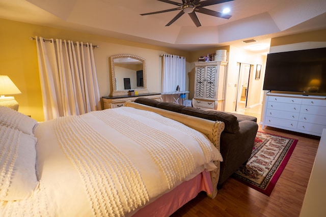 bedroom featuring a tray ceiling, hardwood / wood-style flooring, and ceiling fan