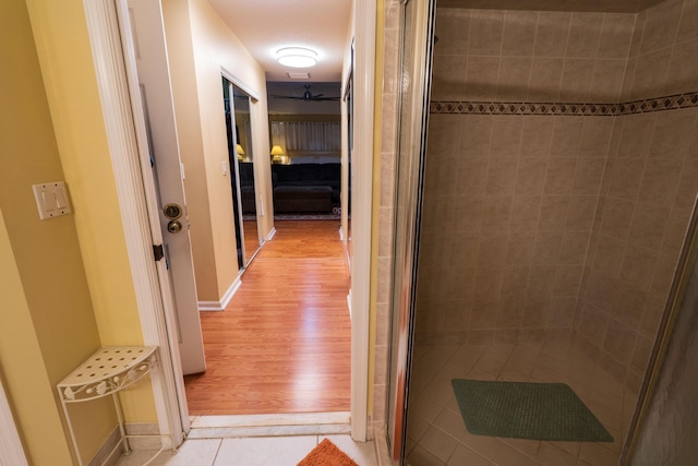 bathroom with hardwood / wood-style flooring and a shower with shower door