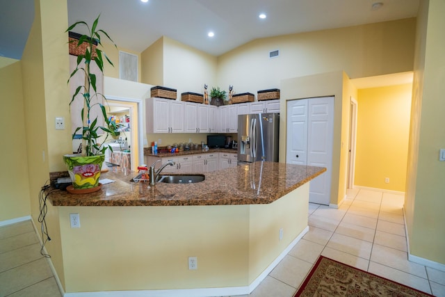 165 Cypress Trce, Royal Palm Beach, FL 33411 - kitchen with stainless steel fridge with ice dispenser, a peninsula, a sink, dark stone countertops, and light tile patterned floors