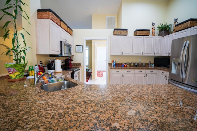 165 Cypress Trce, Royal Palm Beach, FL 33411 - kitchen with stainless steel appliances, a sink, white cabinetry, and dark stone counters