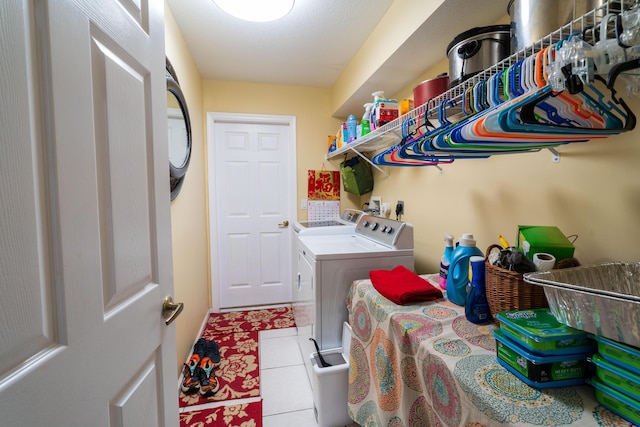 laundry area with light tile patterned floors and washer and clothes dryer